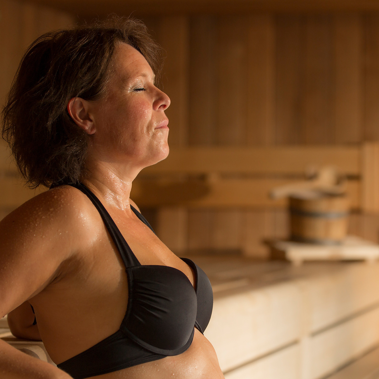Vrouw in badkleding ontspant in sauna 