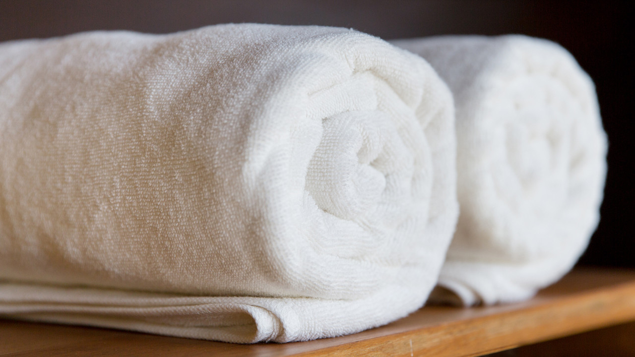 Opgerolde witte badhanddoek op schapje
