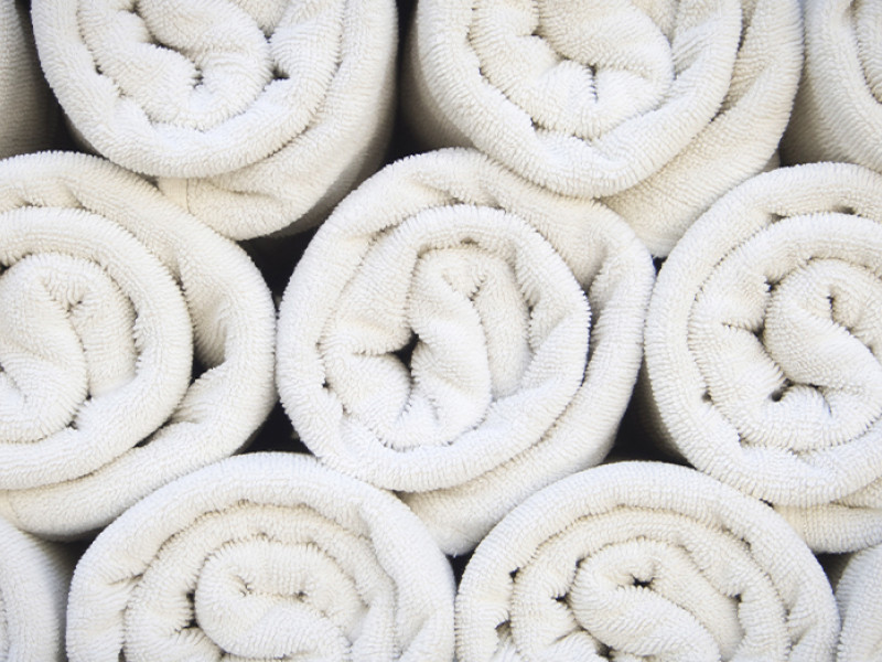 Twee opgevouwen badjassen op een houten achtergrond