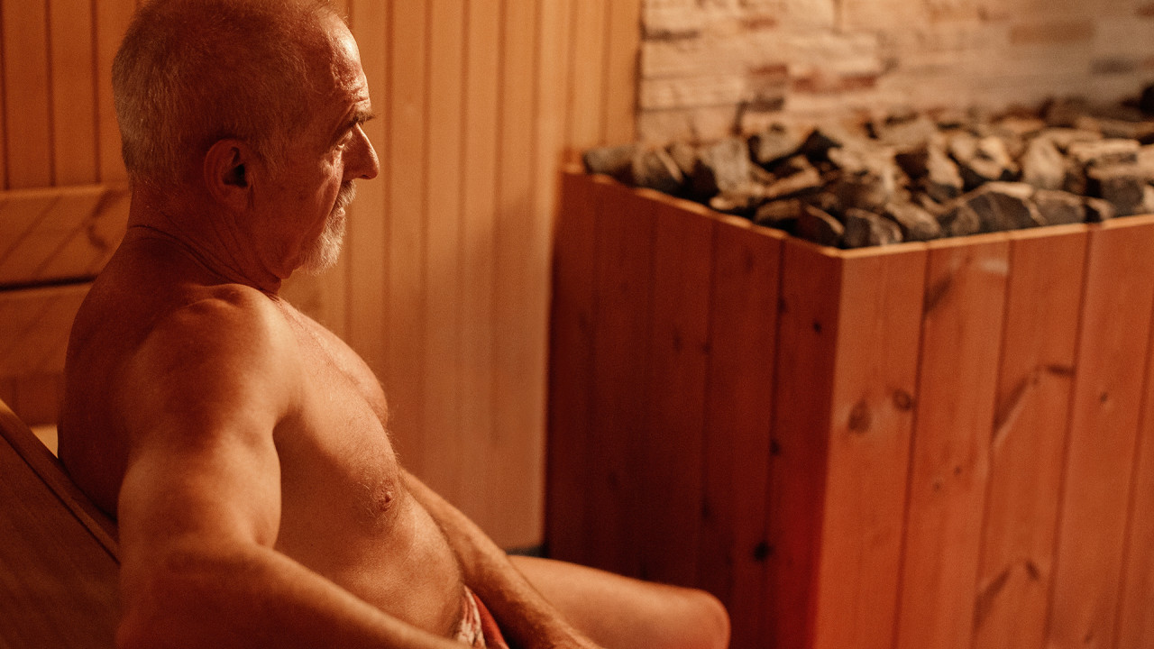 Man in sauna met kachel