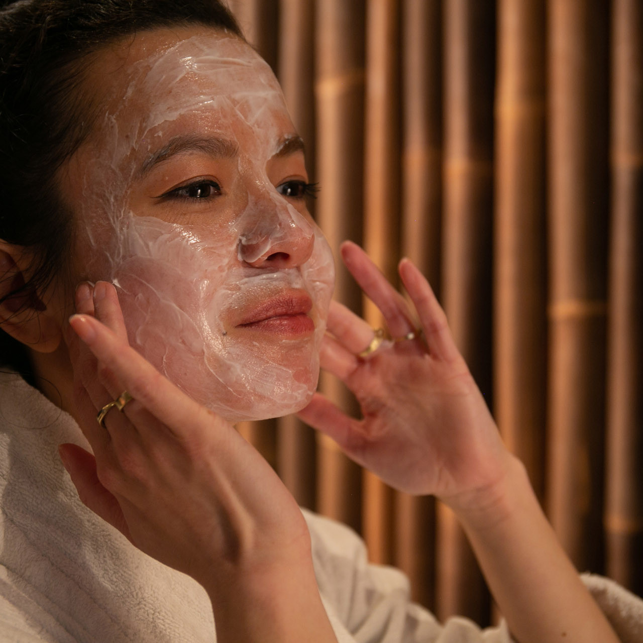 Jonge vrouw brengt facial creme aan op gezicht