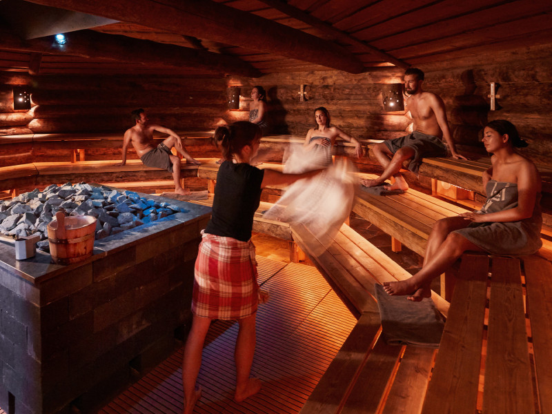 Mensen genieten in sauna van wellnessritueel opgieting