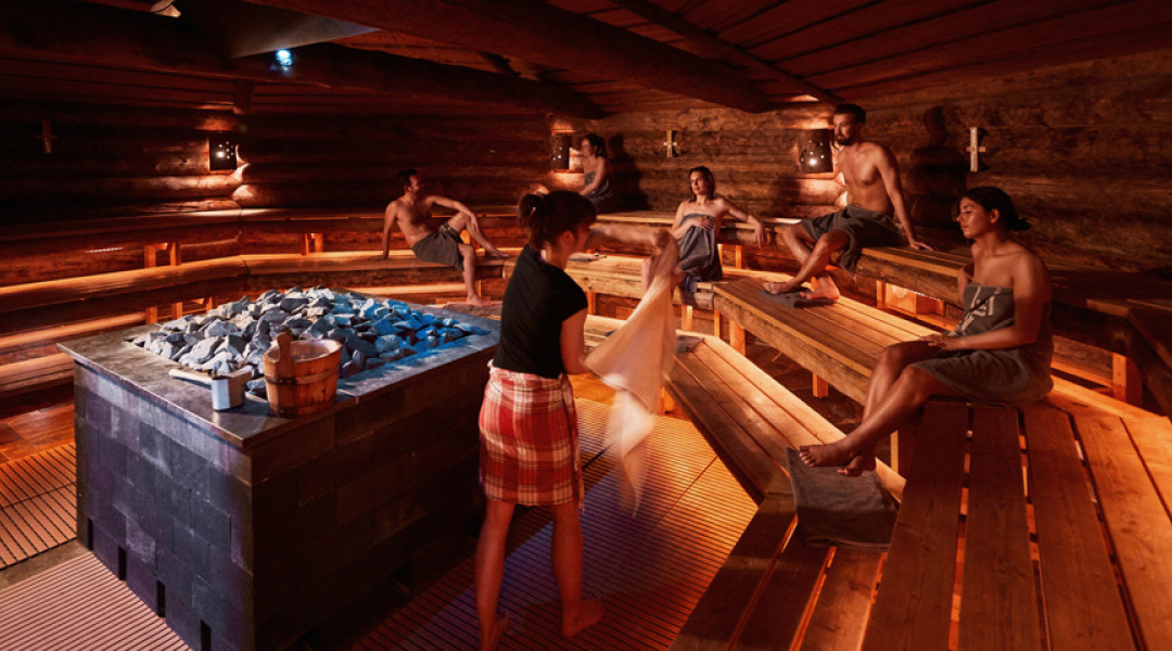 Mensen genieten van opgieting in een sauna