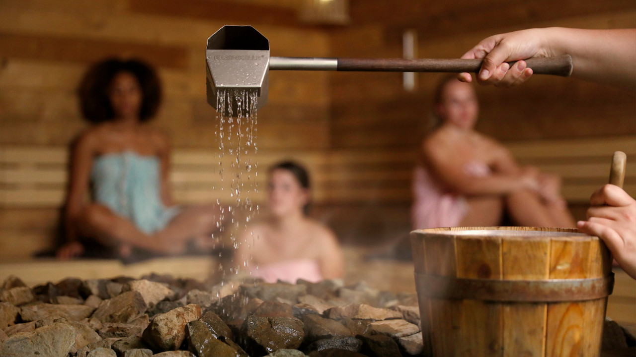 Water wordt over hete saunakachel gegoten tijdens opgieting