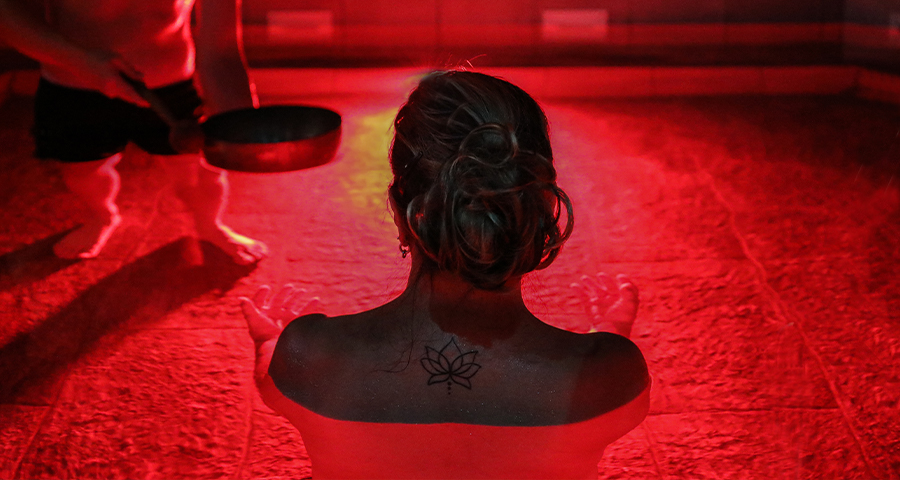 Vrouw geniet in warm bad met rood licht van wellnessritueel