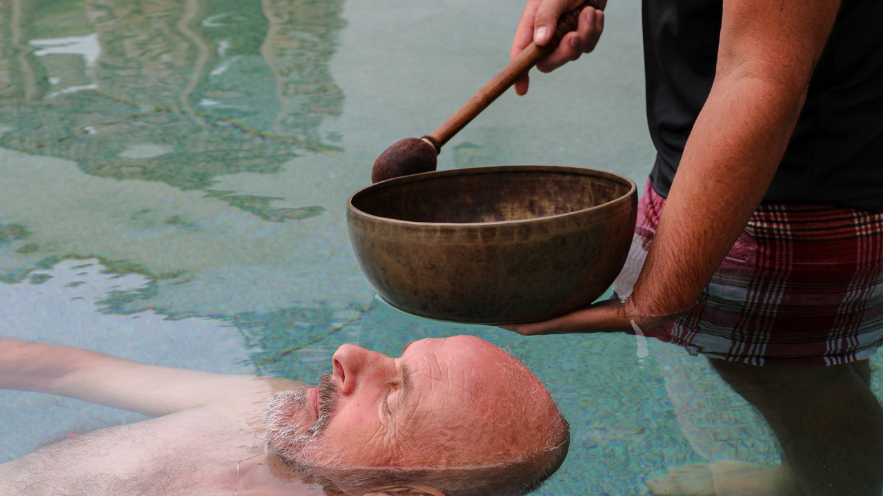 Man ontspant tijdens wellnessritueel in het water