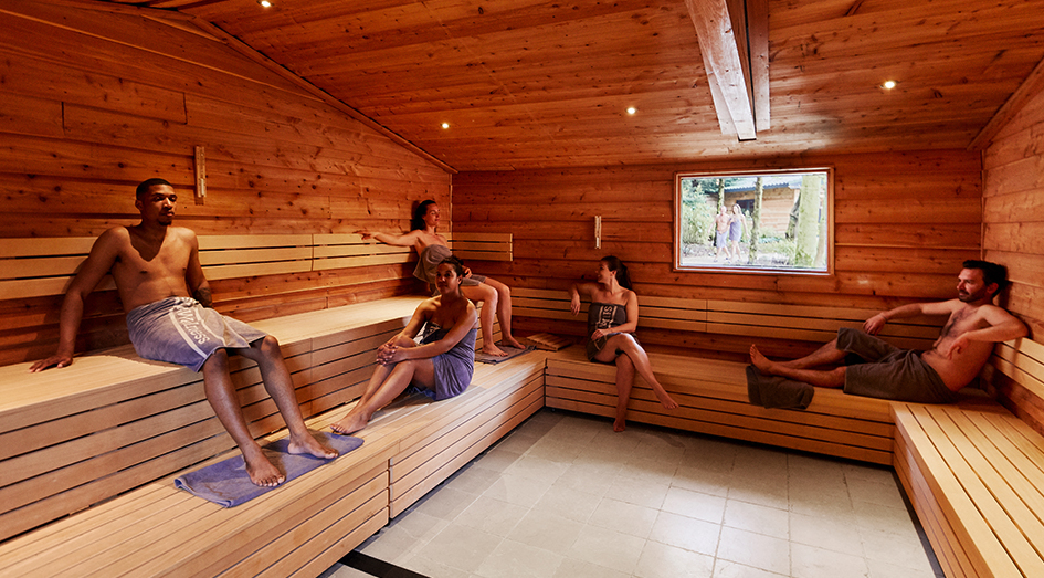 Mensen ontspannen in een sauna in de tuin van Elysium