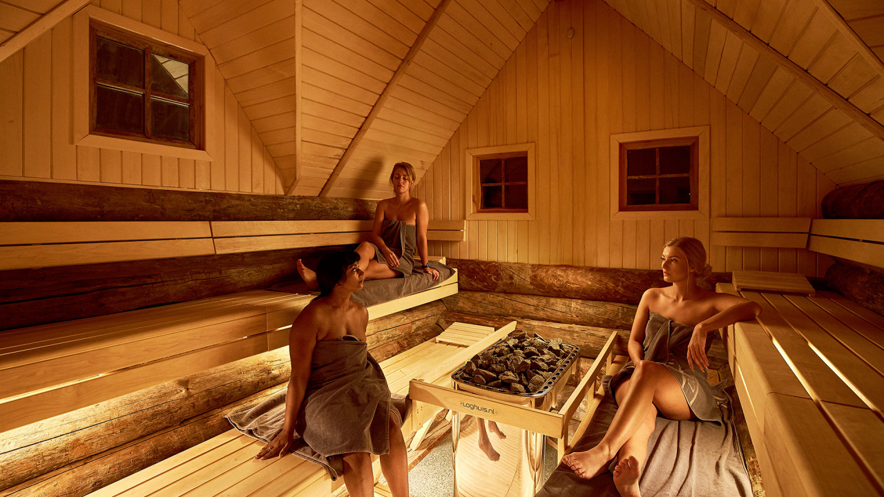 Drie vrouwen in sauna genieten van de aangename warmte