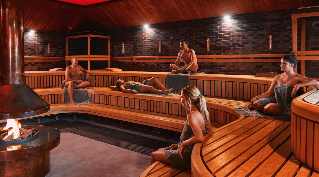 Mensen genieten in sfeervolle donkere sauna bij SpaWell