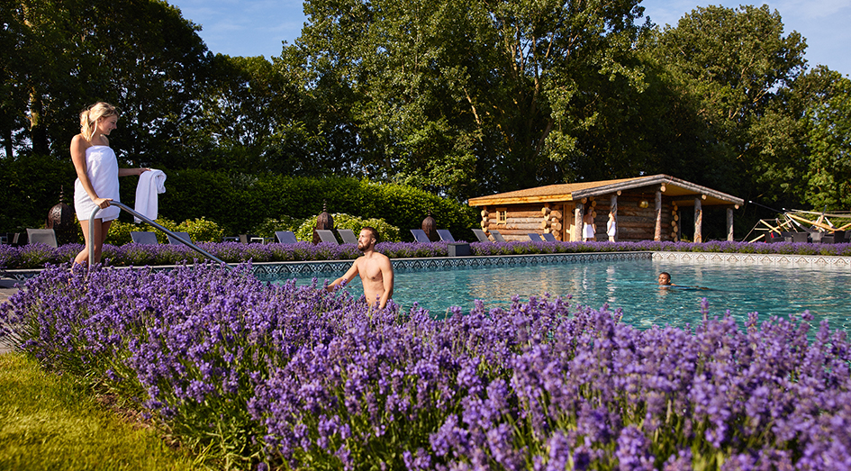 Man en vrouw in buitenzwembad omringd door lavendel