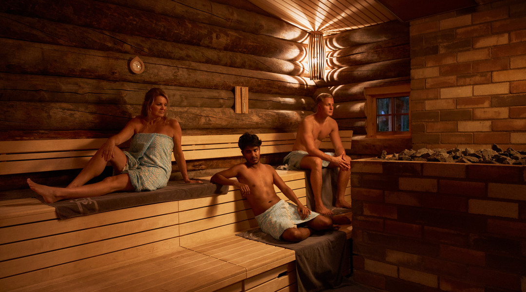 Drie personen in donkere sauna ontspannen